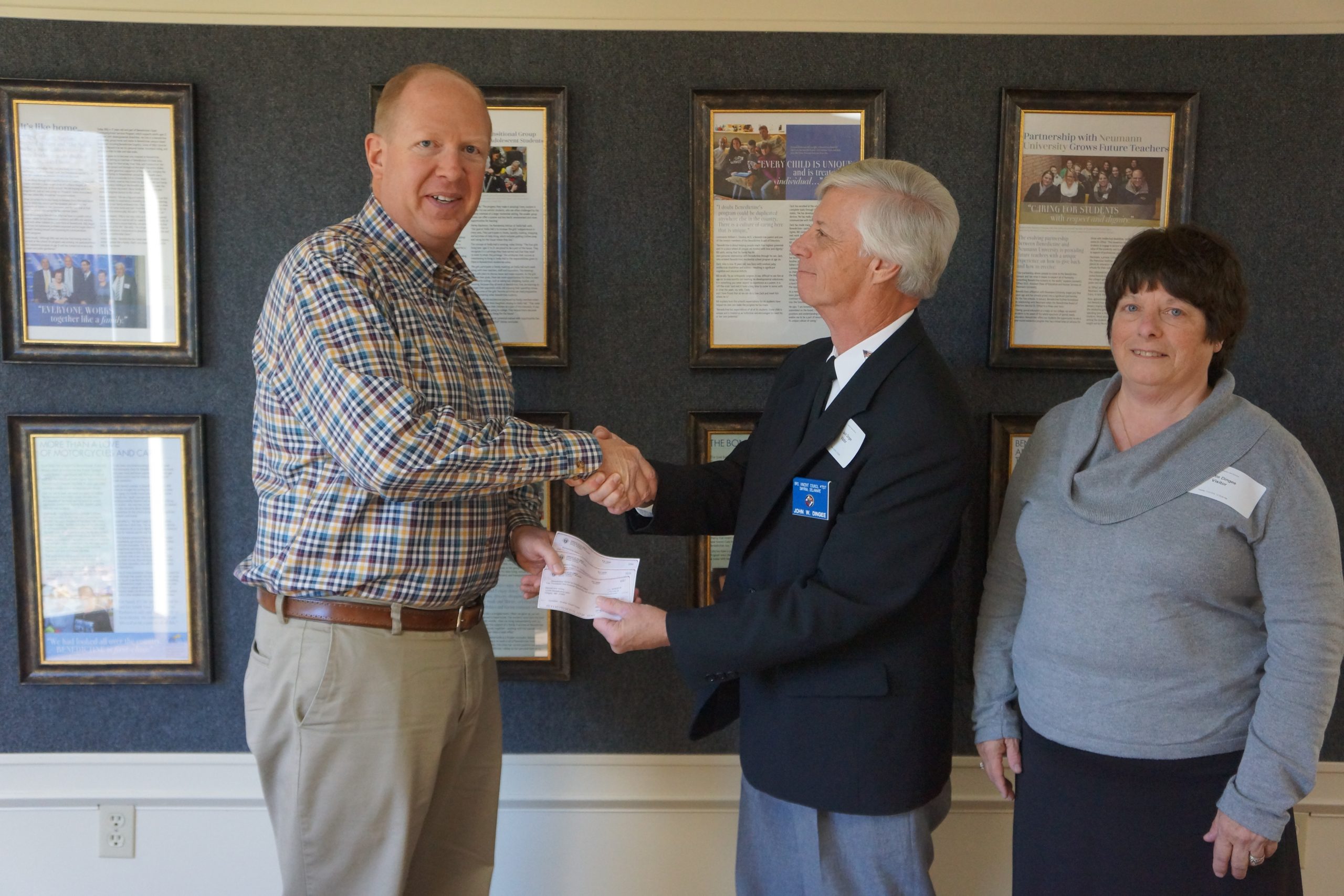 Executive Director accepting donation from Knights of Columbus representatives.