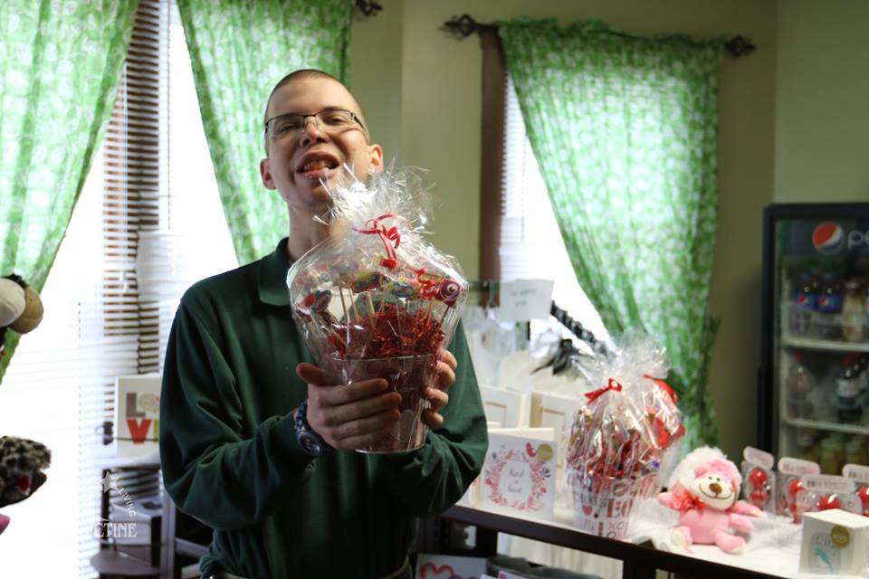 Student holding gift basket at Sweetly Made Bakery.