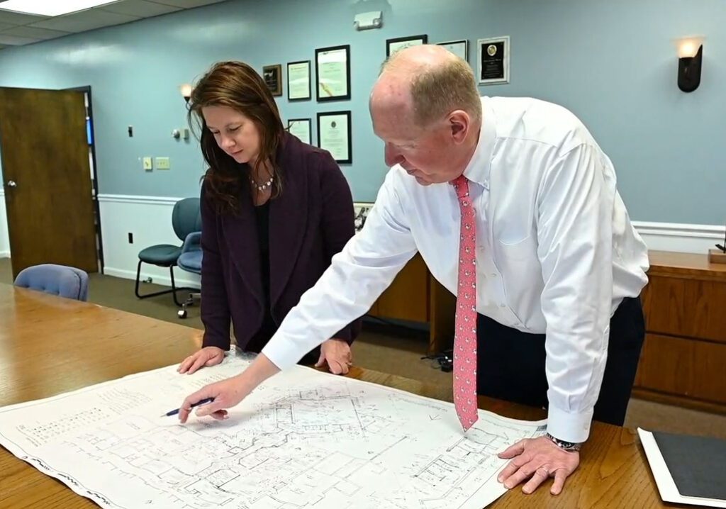 Scott Evans looking at a blueprint with Julie Hickey.